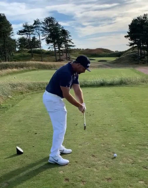 Golfer playing an iron shot on the course
