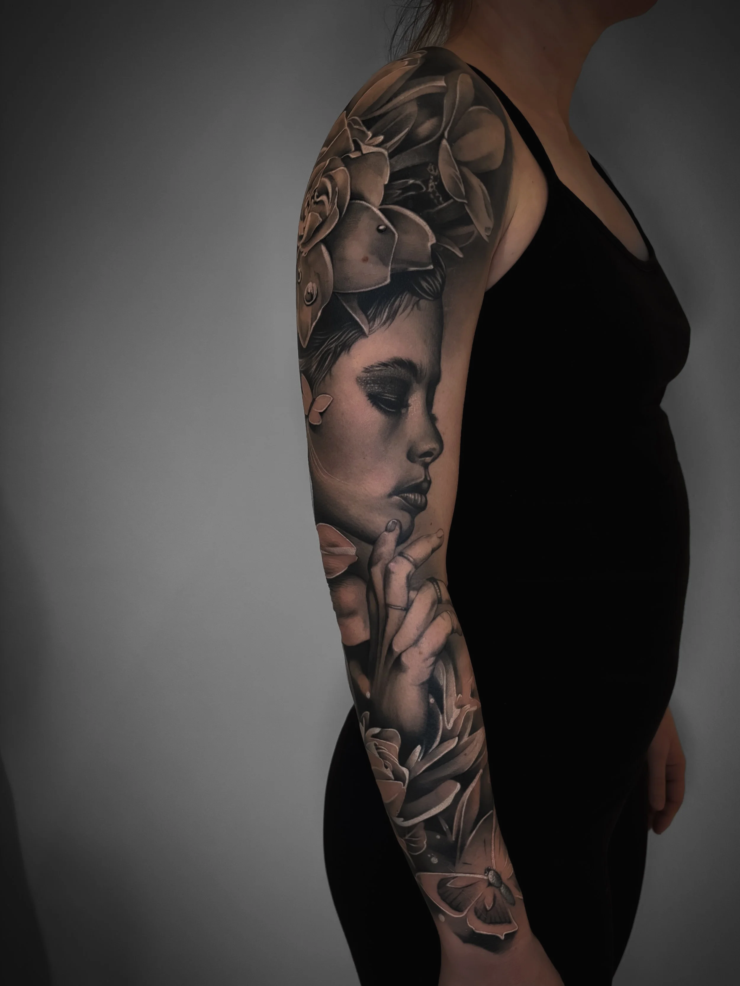 Frauen Portrait Tattoo sleeve im realistic Black & Grey Stil mit Blumen und Schmetterling – gestochen von Julia Theodora im Saarland