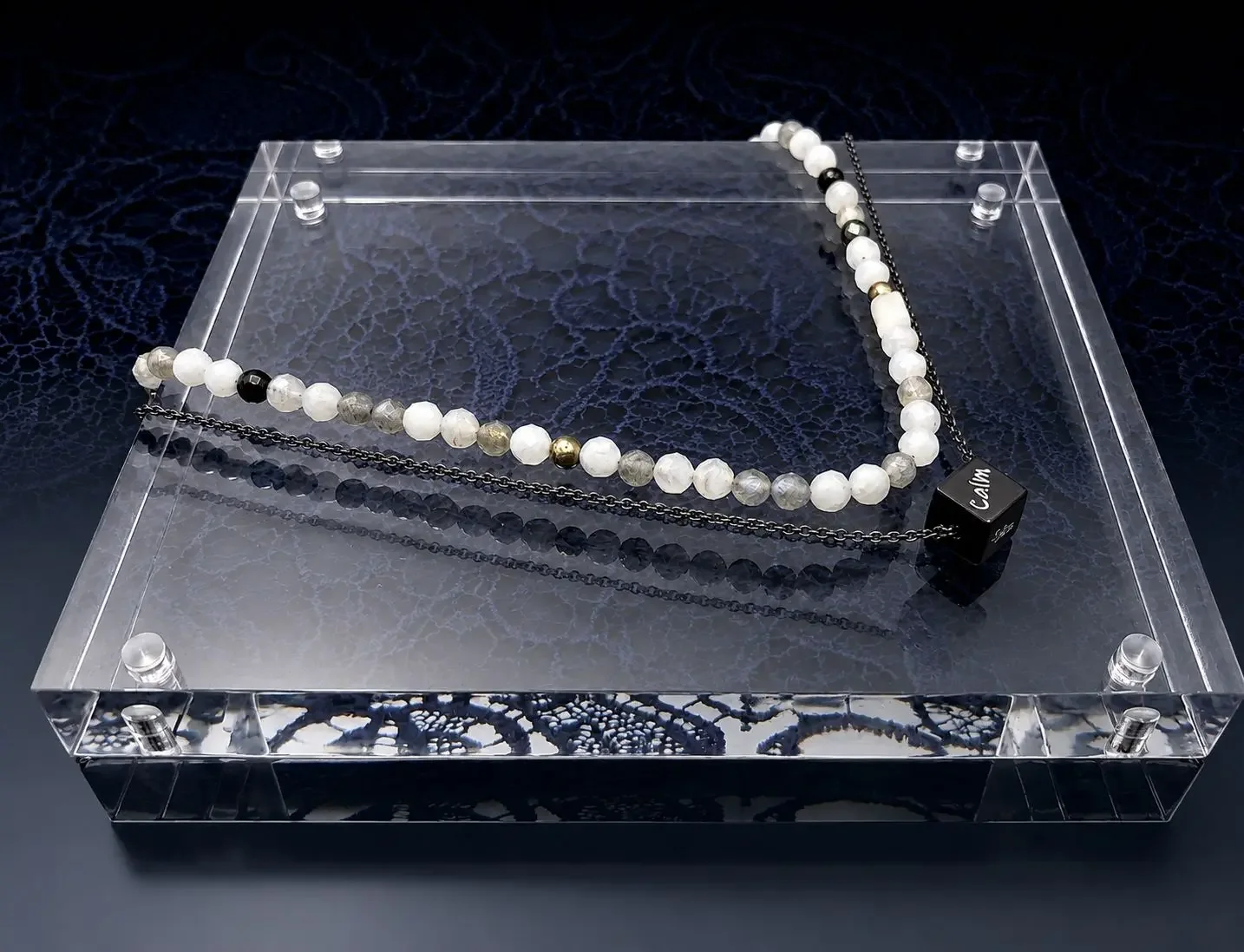 Scented emotions winter diffuser double strands necklace, with semi precious stones and meaningful words engraved on pendant. showcased on a winter color-theme display to remind you to reflect, rest and recoup.