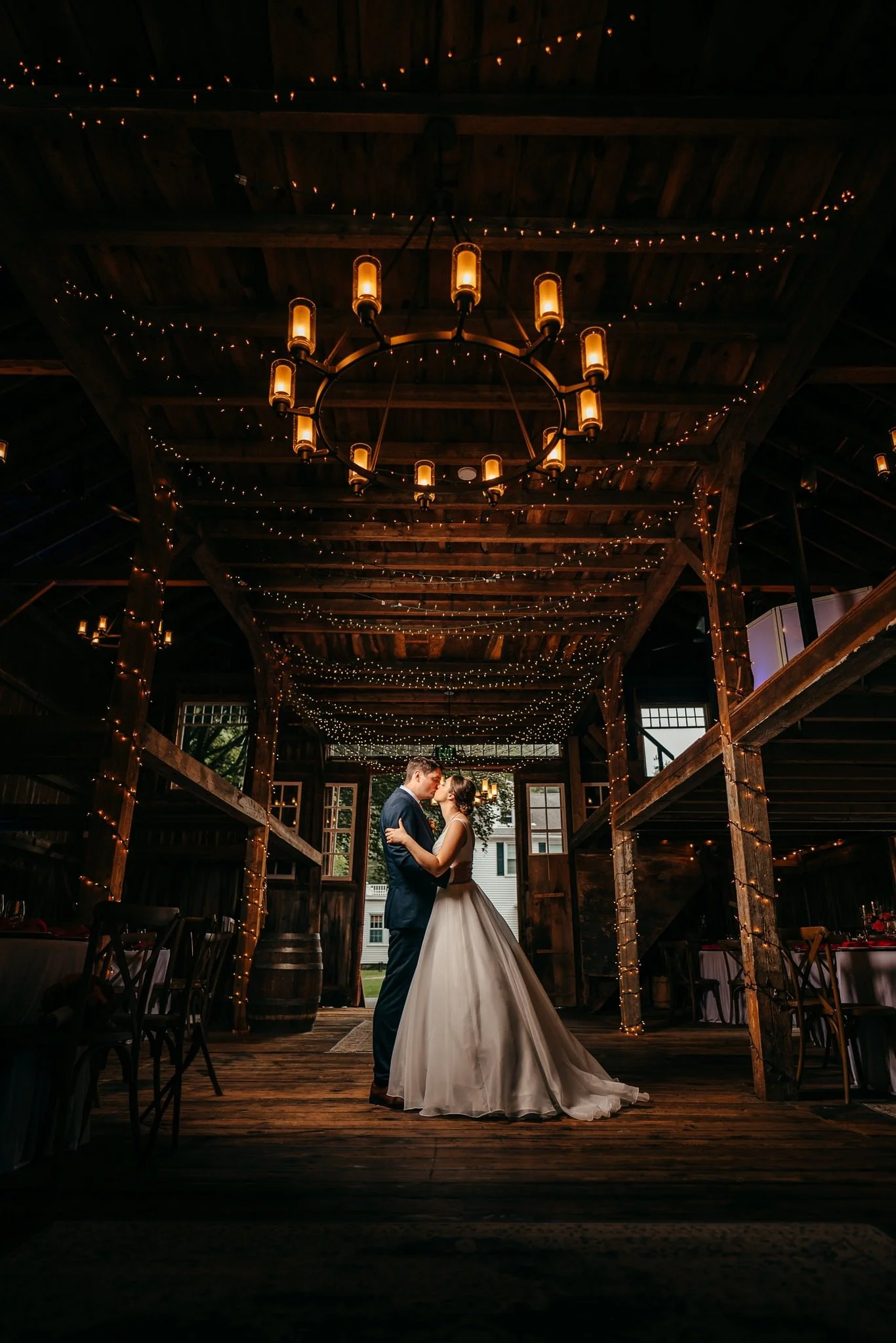 Couple pose in lit barn