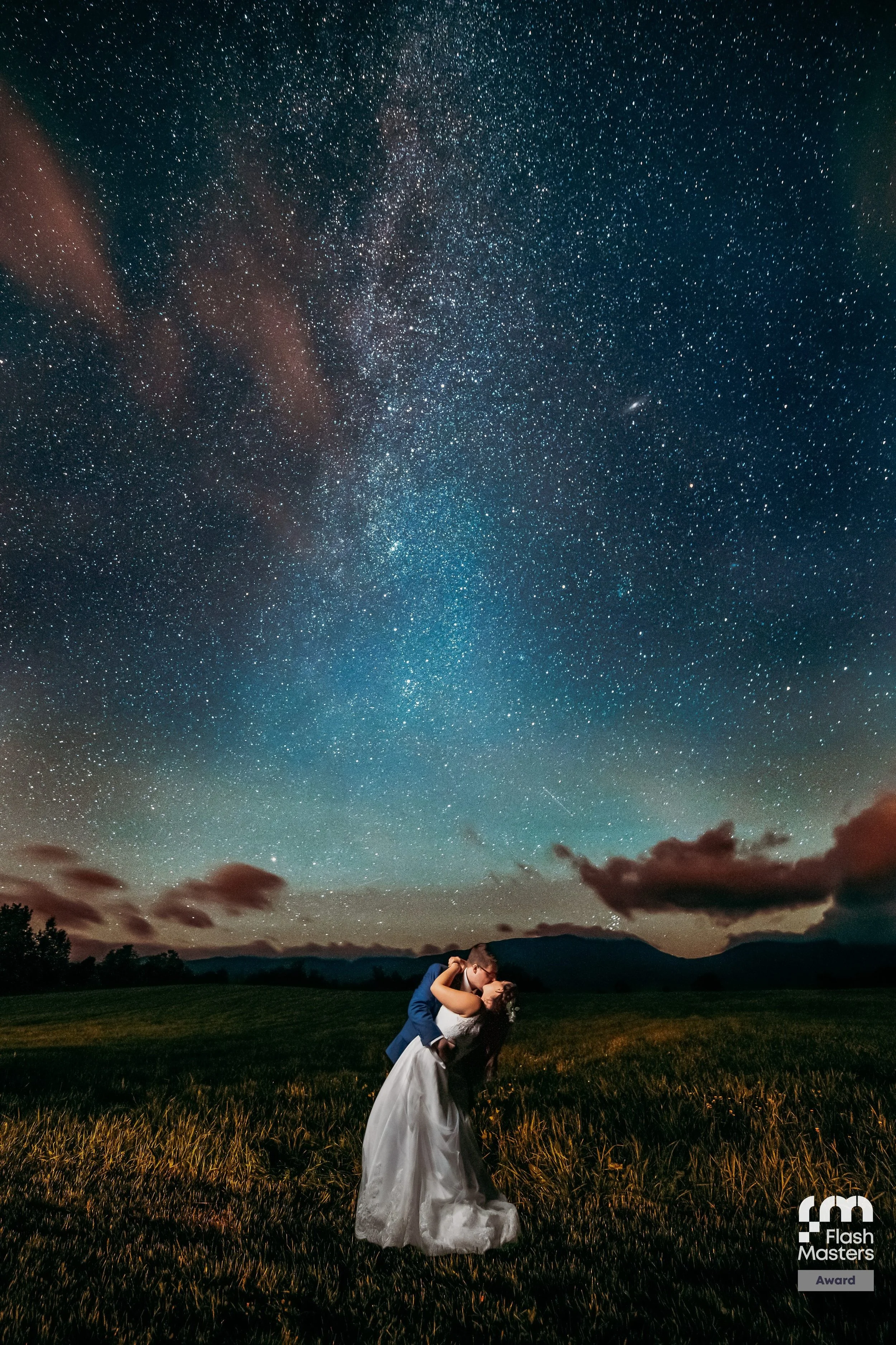 A couple posing in a lighted up renovated barn