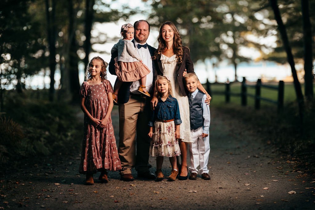 Haynes family of six on a wooded path during a fall portrait session in Concord, NH