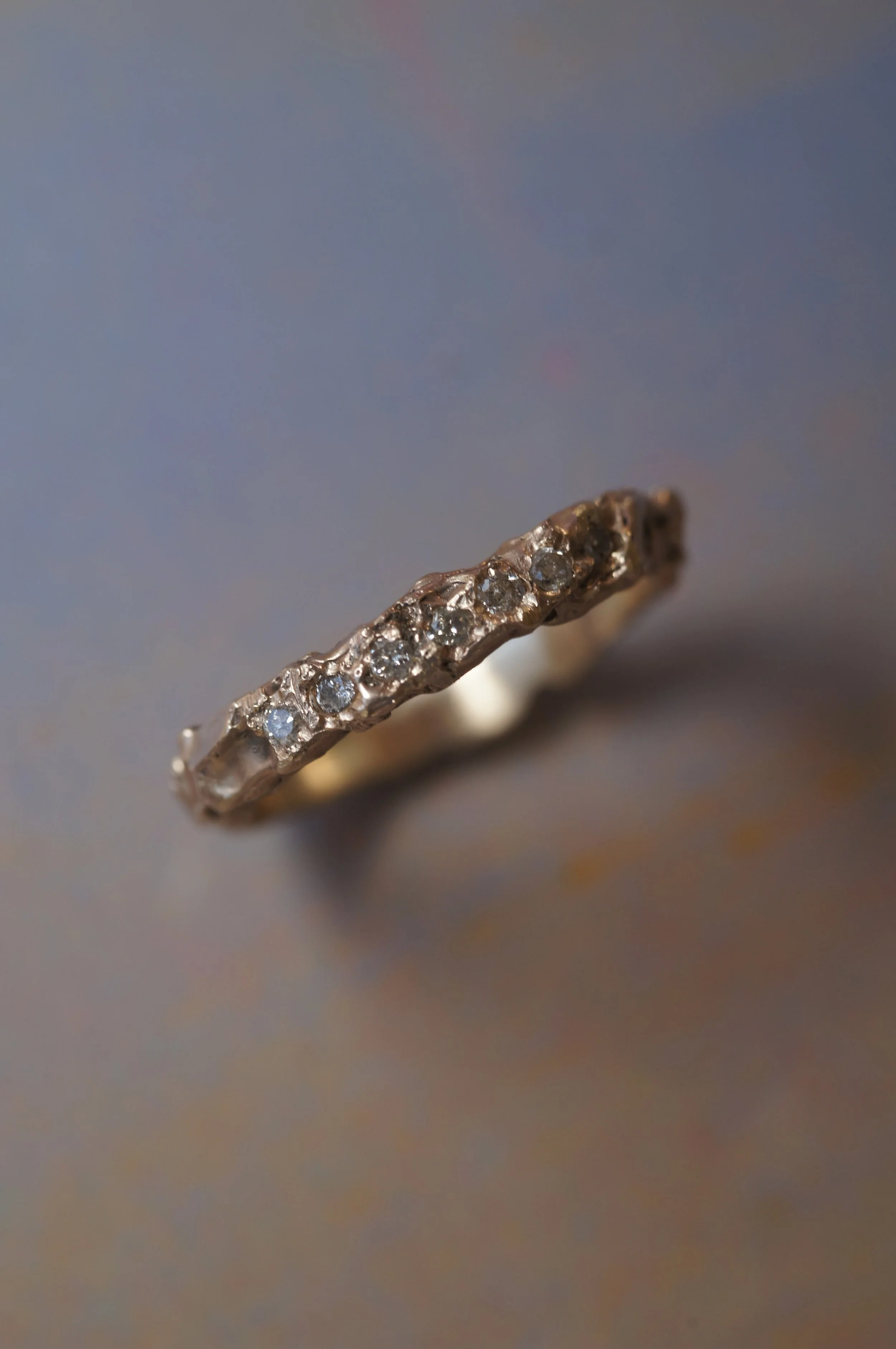 Close-up of a ring with multiple small diamonds set in a gold band.