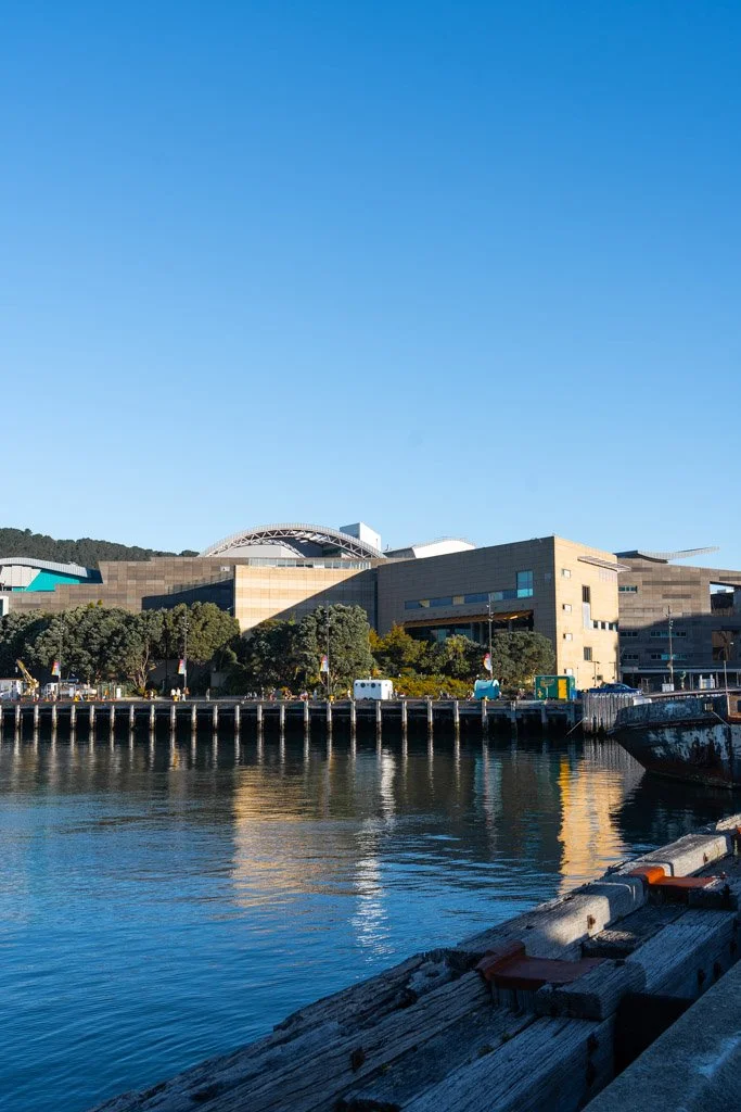 Te Papa museum in Wellington, a large sandy coloured building reflected in the water of the harbour