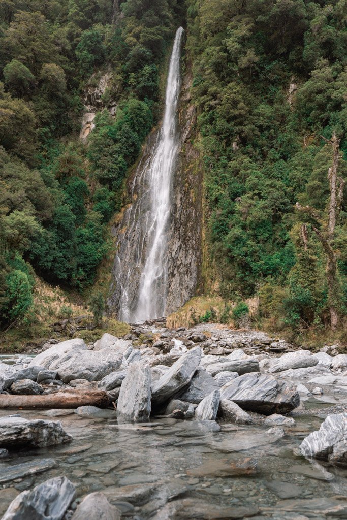 A waterfall flows down a steep cliff