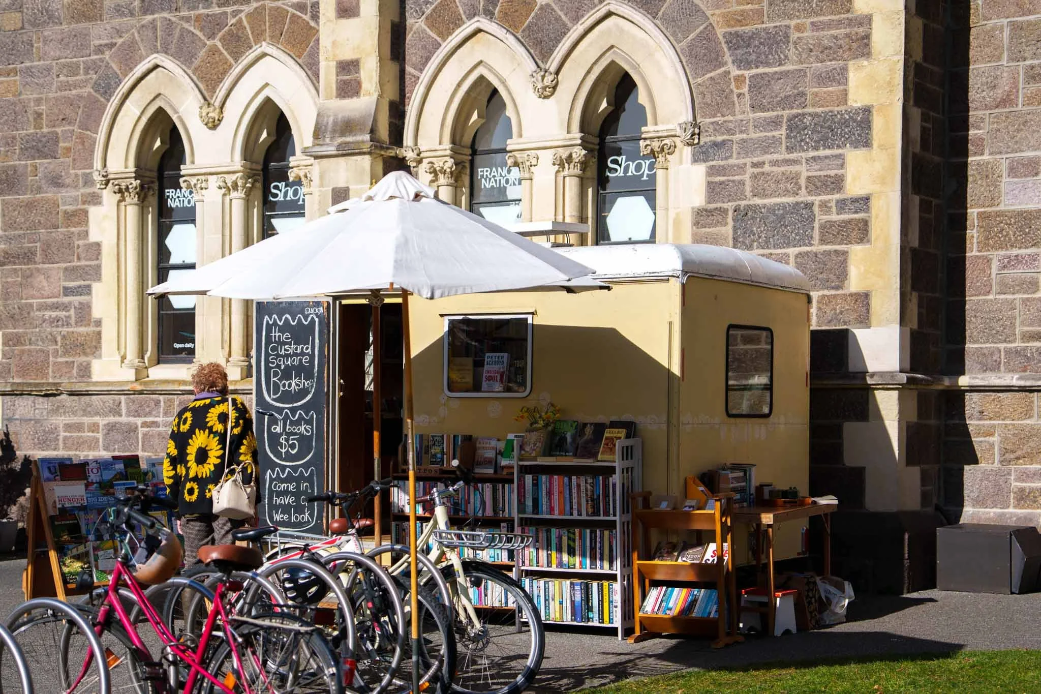 A woman browses books on a shelf at the Custard Square bookshop in Christchurch