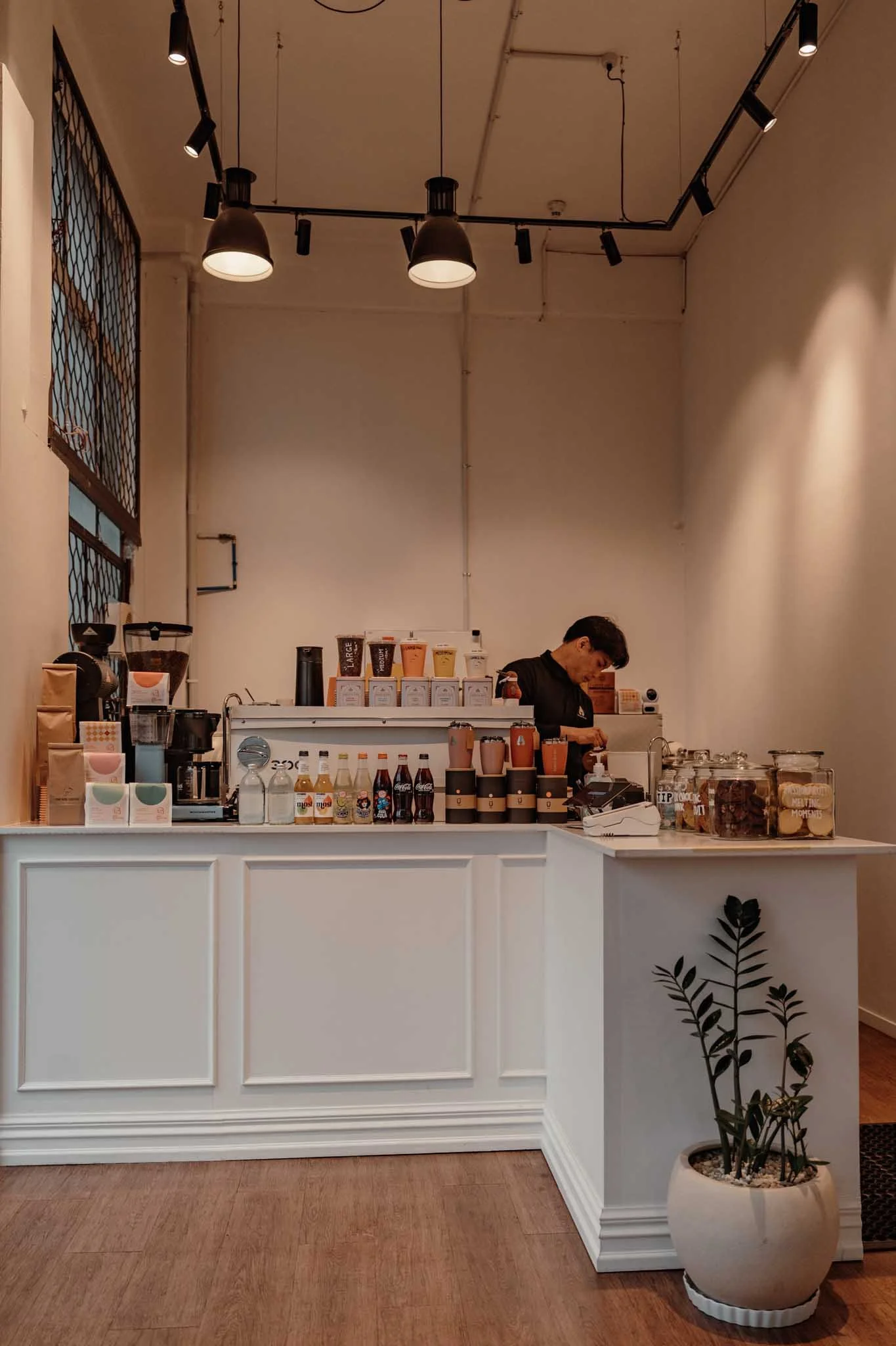 A person makes coffee at a central Auckland cafe