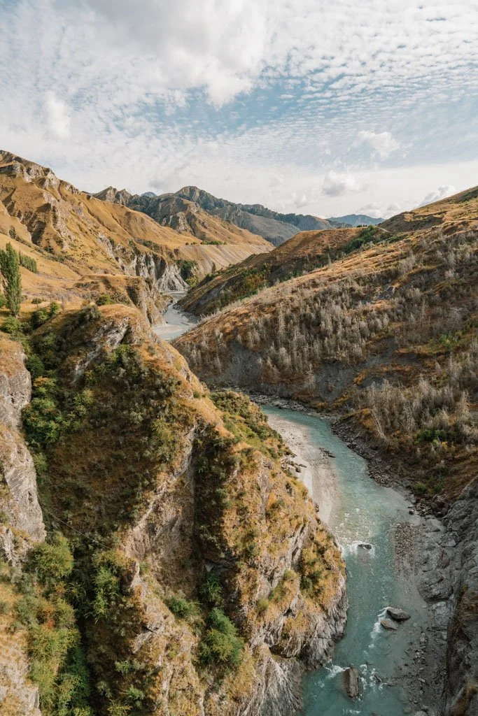 A bright blue river flows through a deep canyon