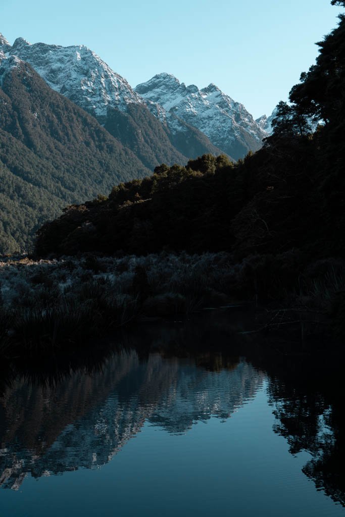 The Mirror Lakes on the Milford Road reflect snowy mountains in still water