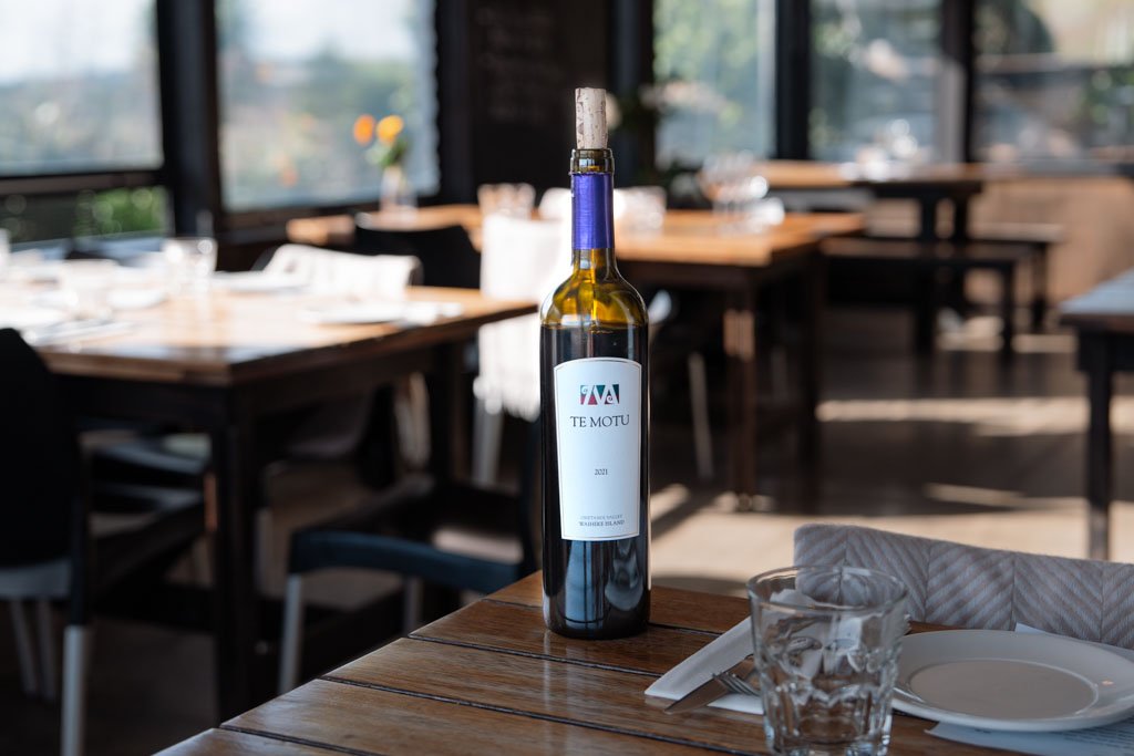 A bottle of Te Motu wine sits on a table in a restaurant