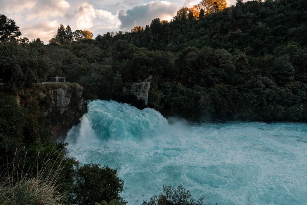 Bright blue water surges over Huka Falls