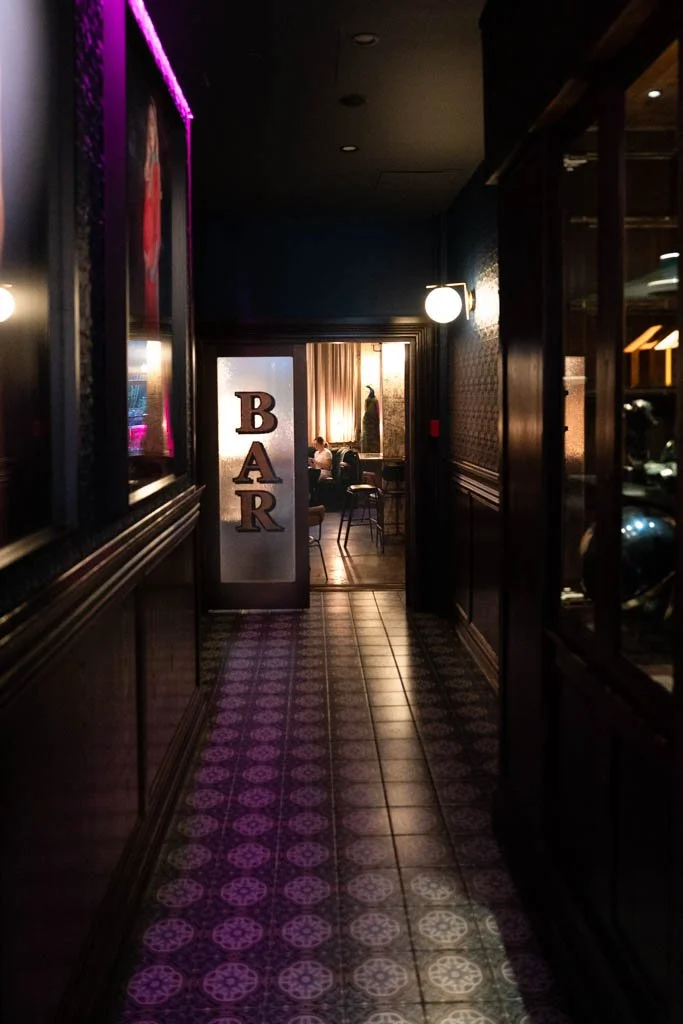 A neon lit hallway leads to a bar at the Intrepid Hotel in Wellington