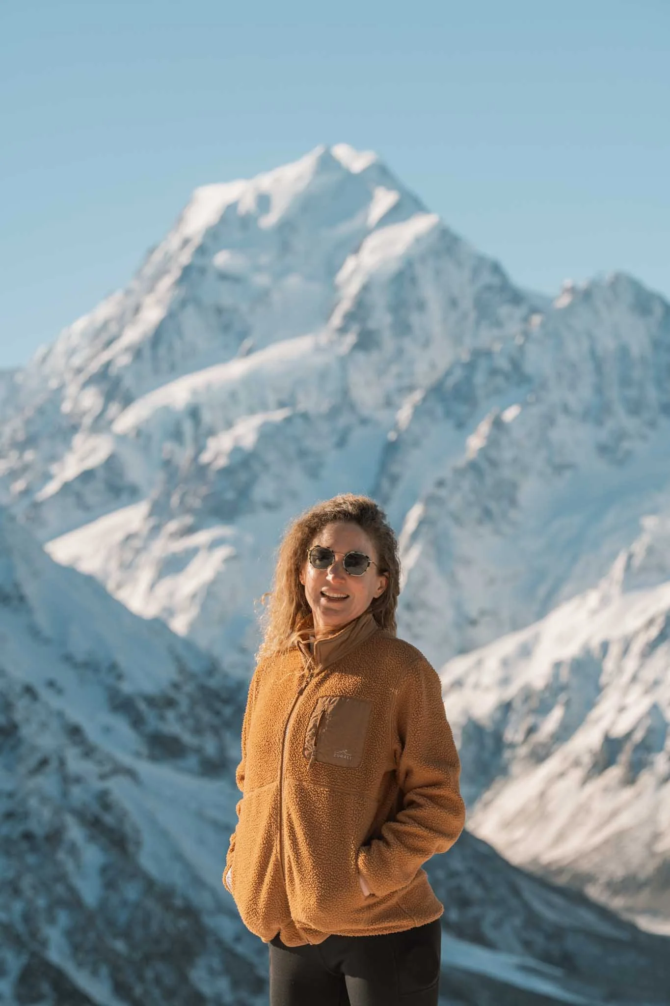 A hiker stands in front of Aoraki Mount Cook