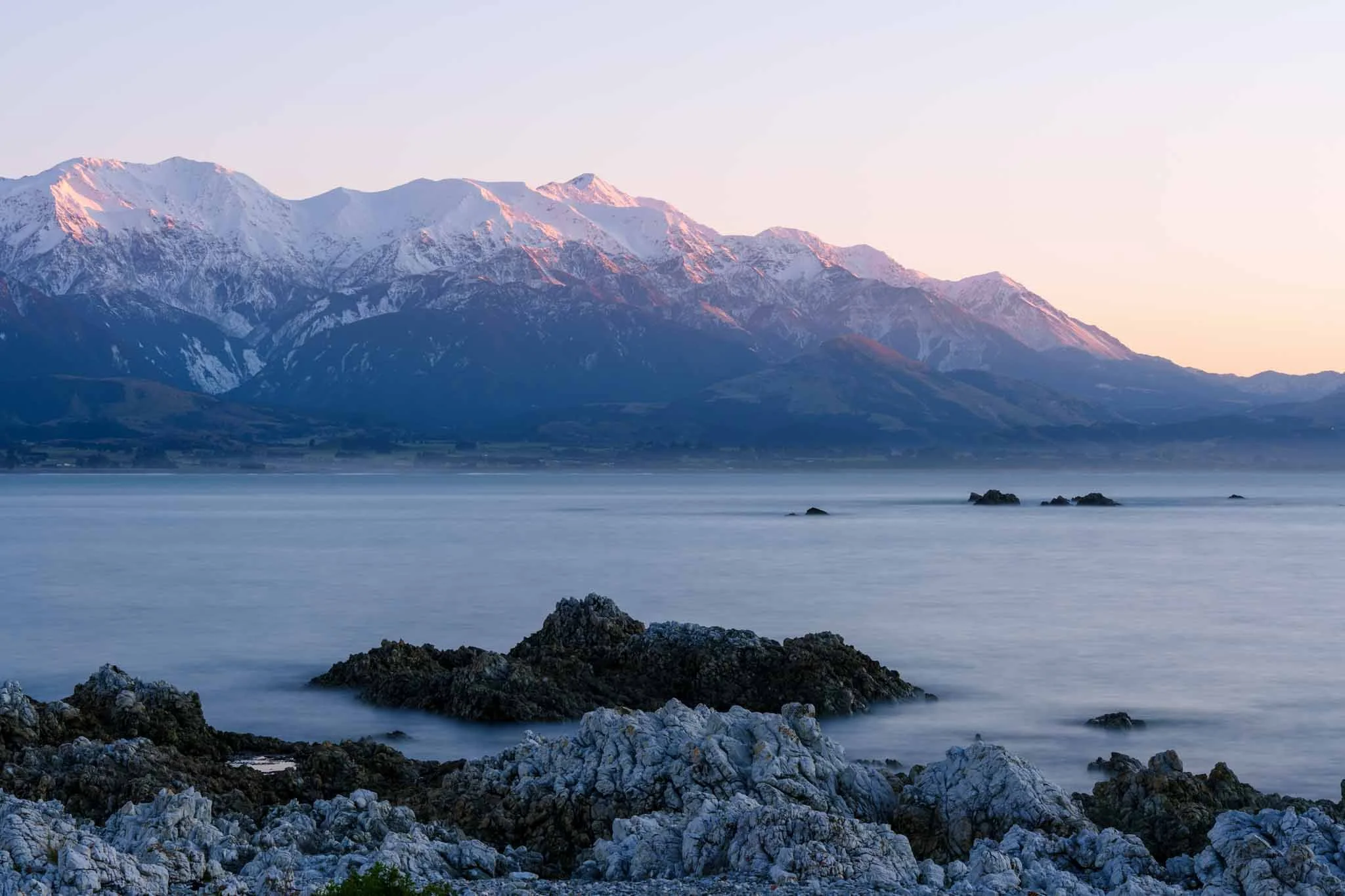 Dawn colours the mountain range above Kaikoura pink