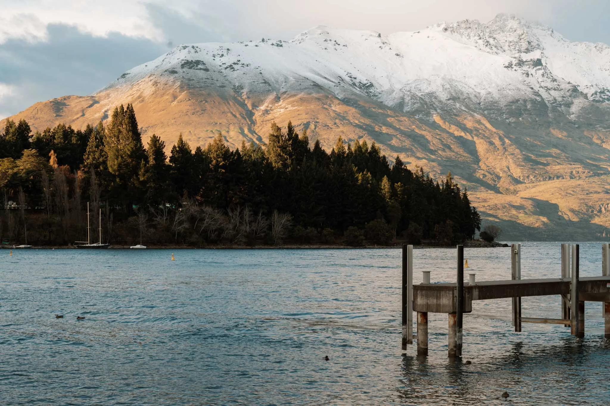 Sunlight highlights the snowy mountains in Queenstown