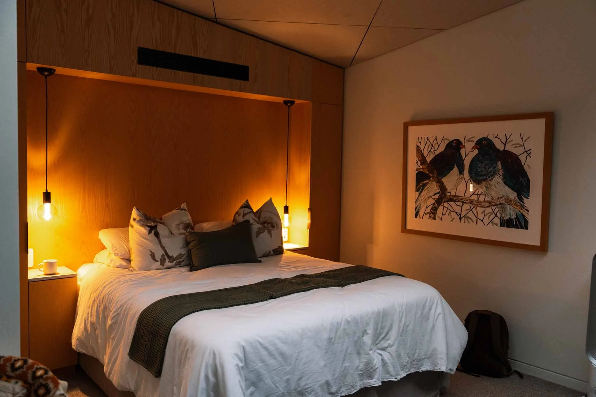 A hotel bed with lamps on either side