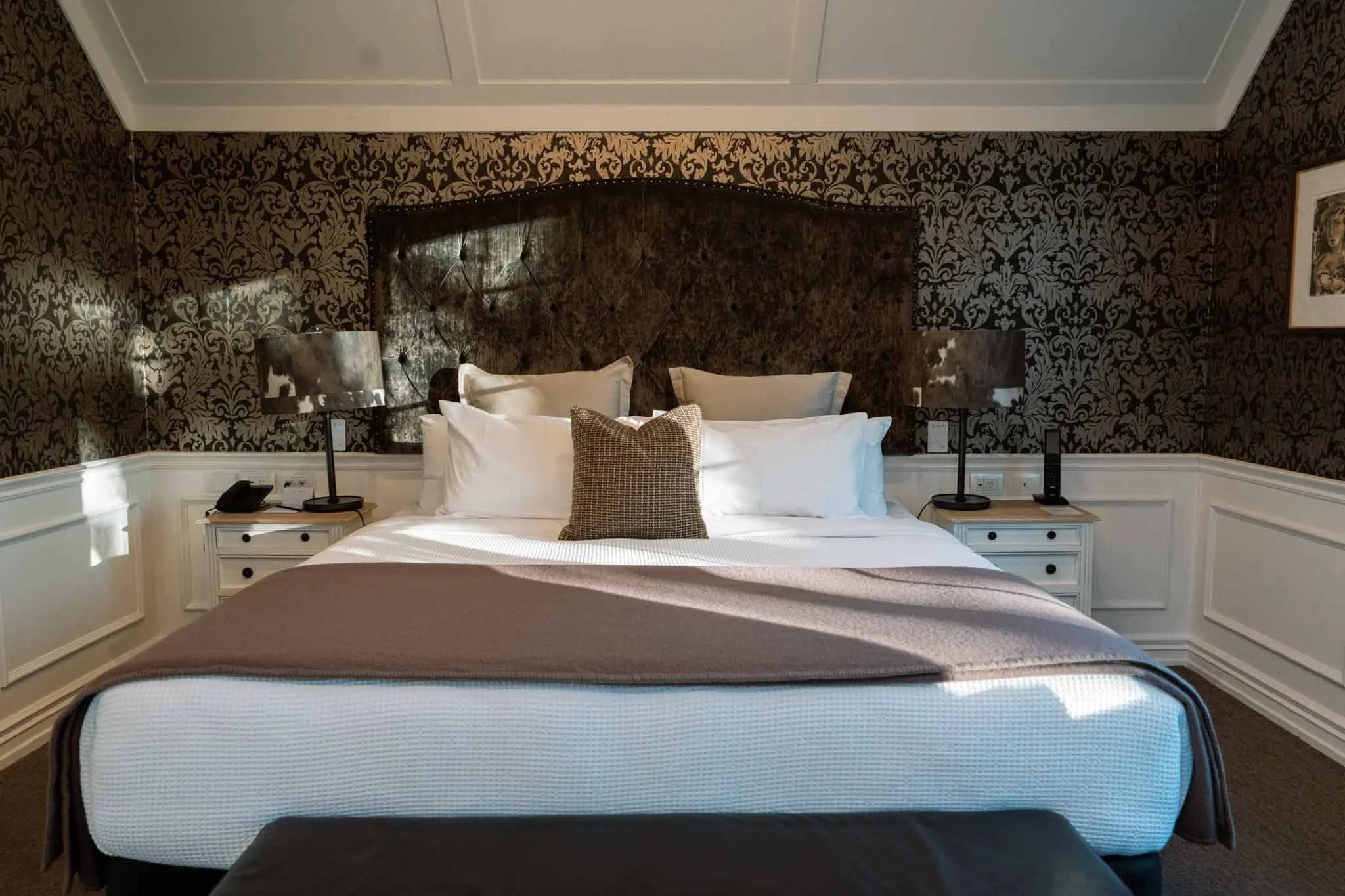 Sunlight dapples a bed at the George hotel in Christchurch