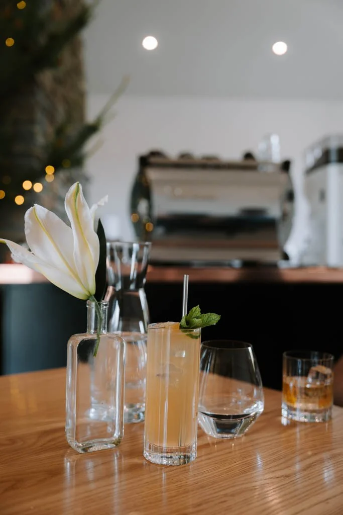 Whisky cocktails on a table with a lily in a jar of water