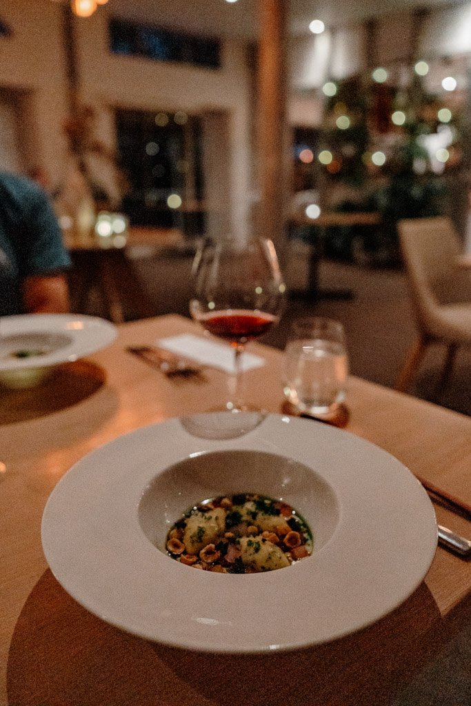 A plate of food sits next to a glass of red wine