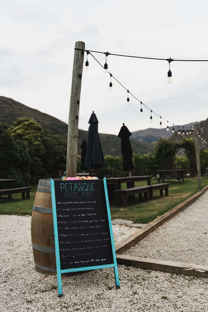 A sign leaning against a wine barrel reads 'petanque'
