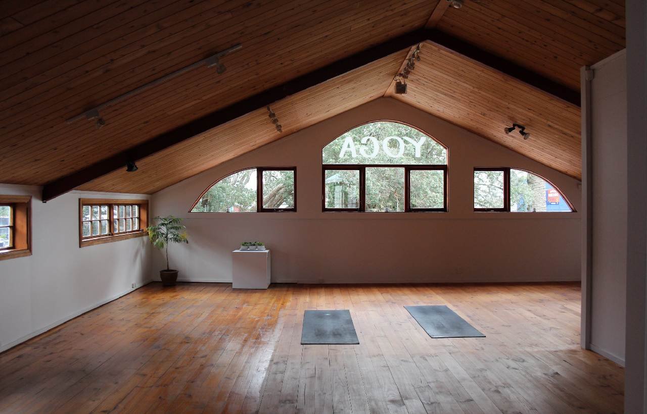 a loft yoga space with wooden floors and an a frame roof