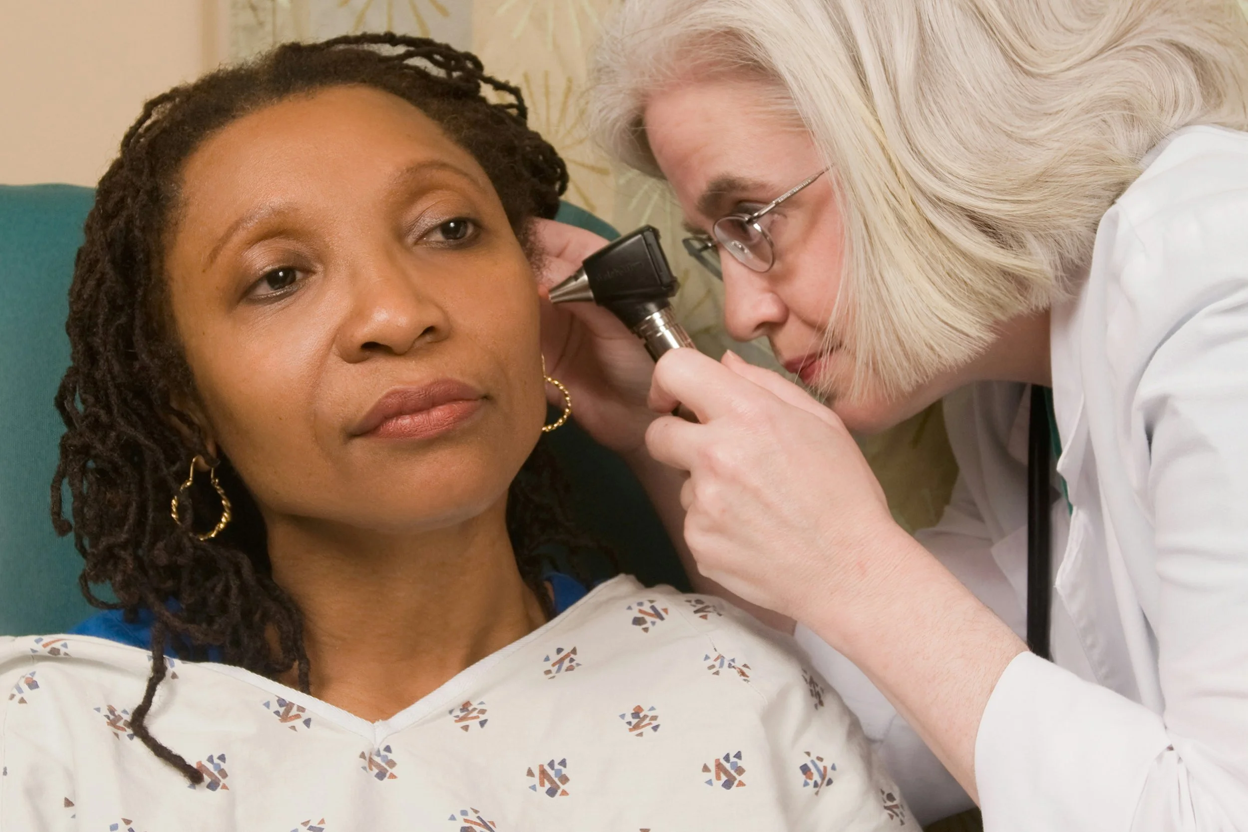 A doctor examines a woman's ear