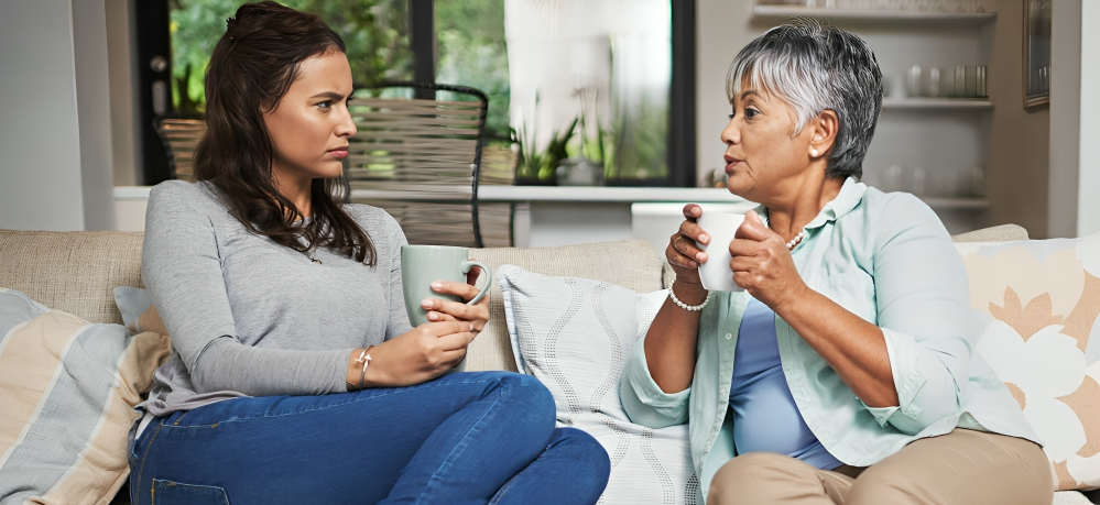 Young adult woman having a difficult conversation with her mother over coffee