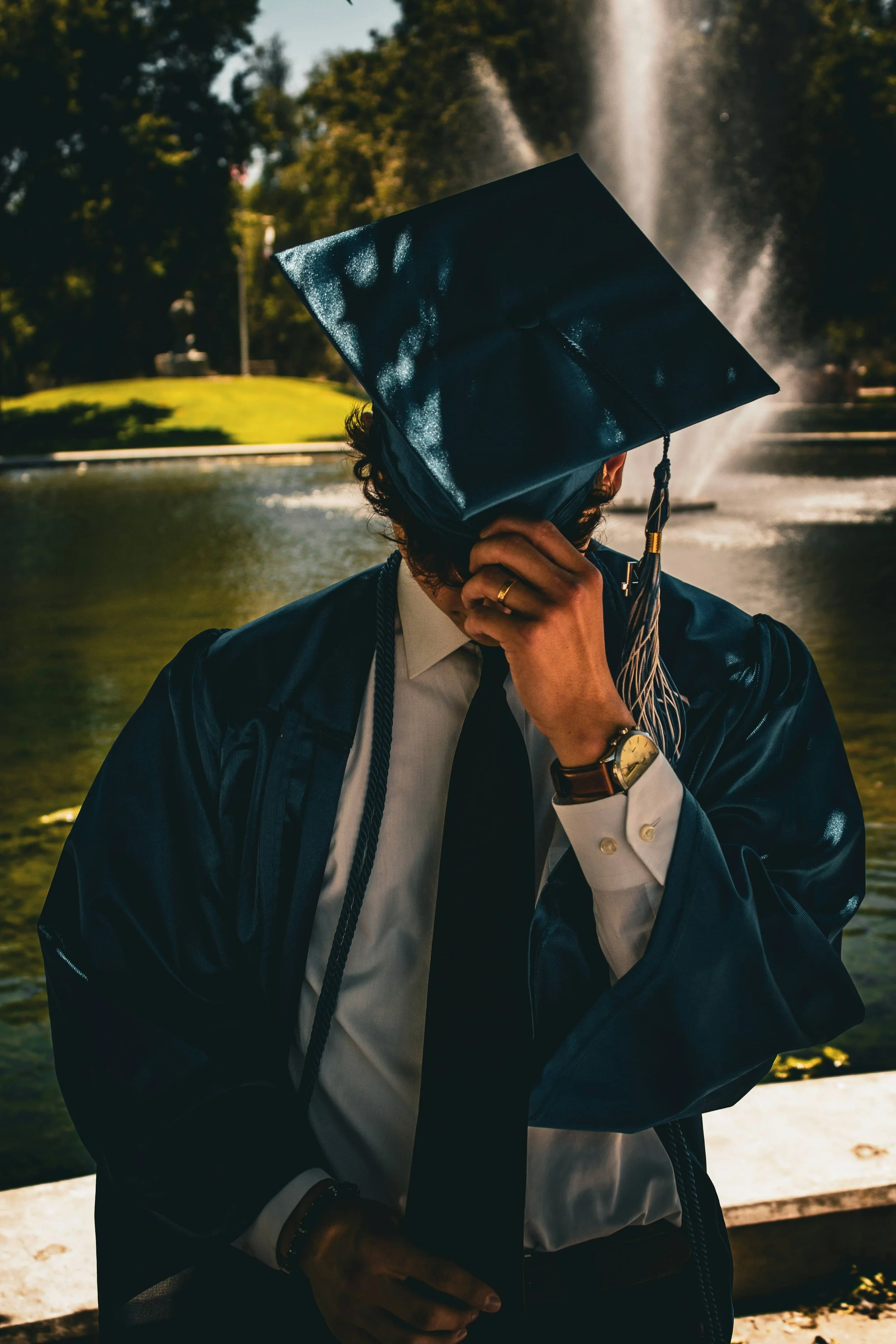 Recent college graduate overwhelmed after graduation, hand covering face