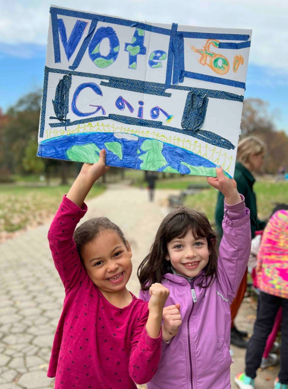Wonder Kids hold up election signs during summer camp about democracy in Brooklyn