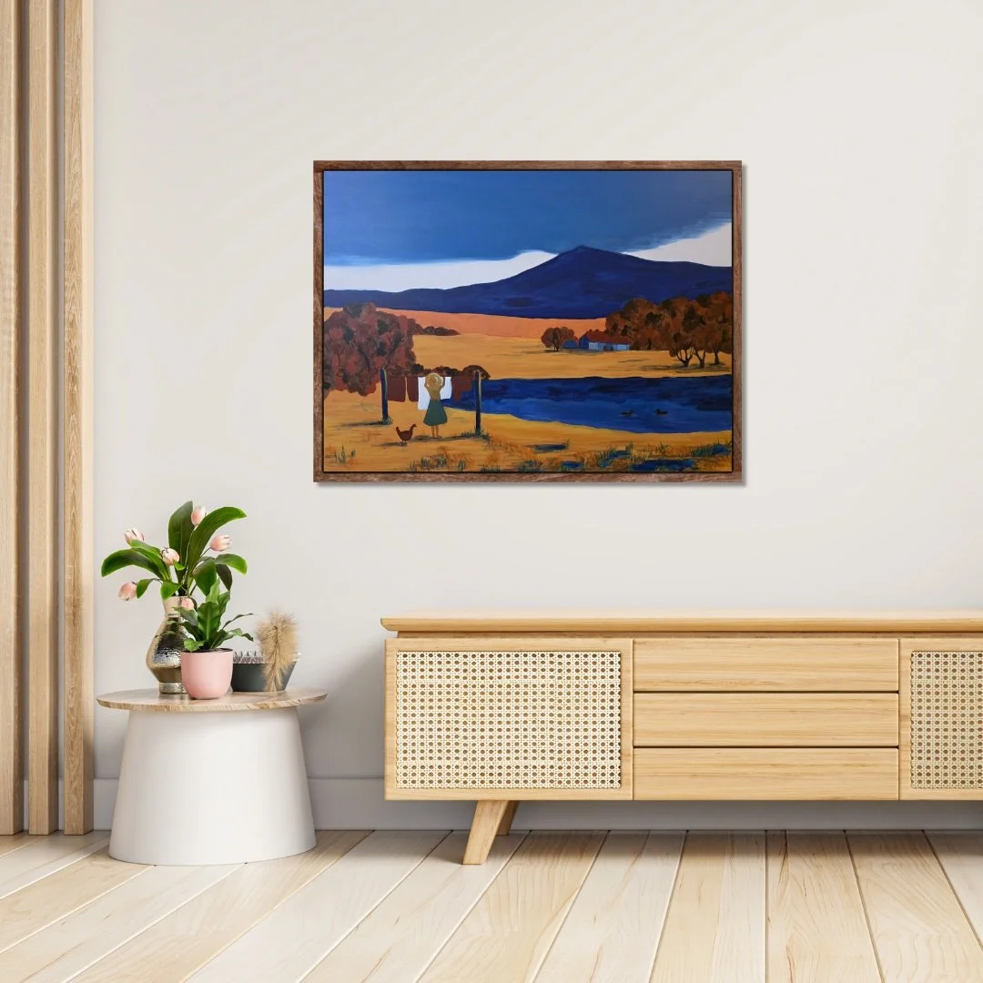 A calm room with a wooden cabinet, a plant, and the framed Silence of the Land abstract artwork painting hanging above it.