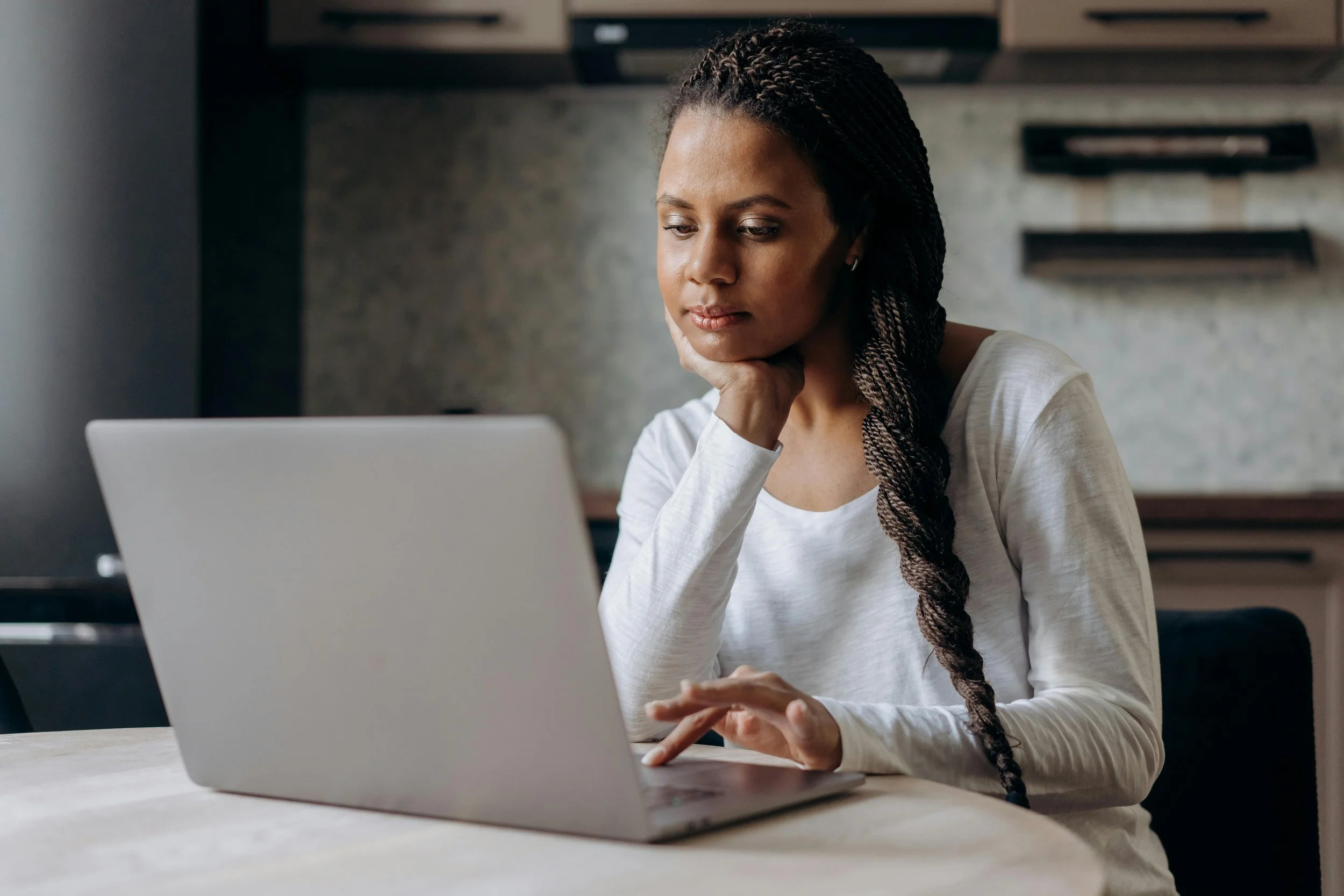 a woman sits at her laptop working