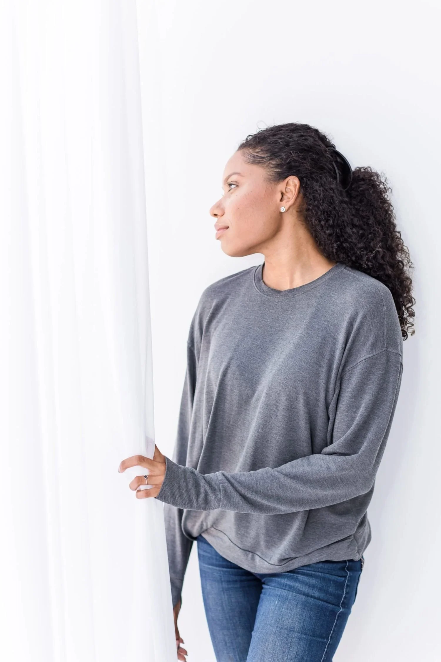Black woman looking out a window, reflecting on anxiety and stress, representing anxiety therapy in New Jersey