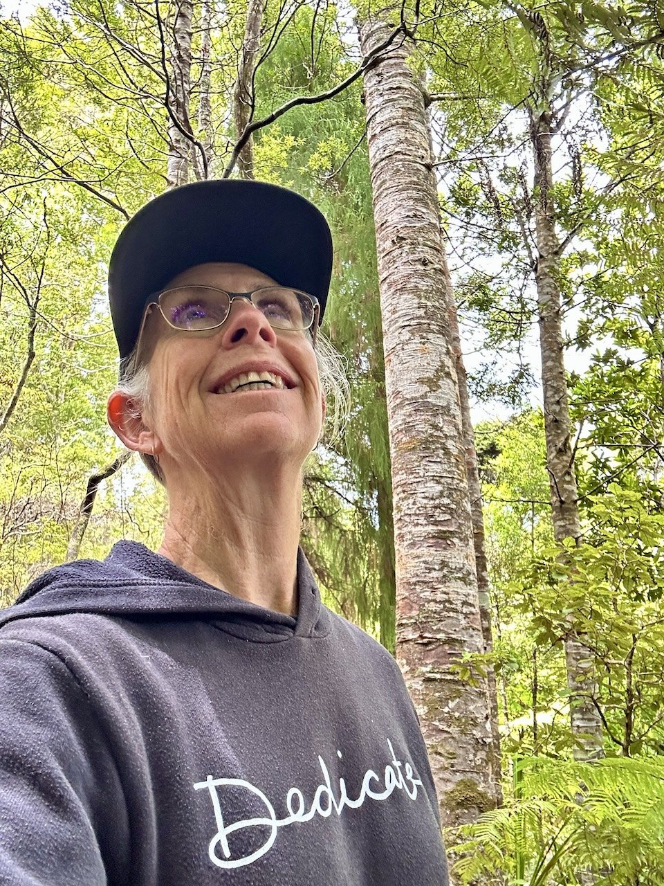 Smiling woman amongst young kauri rickers