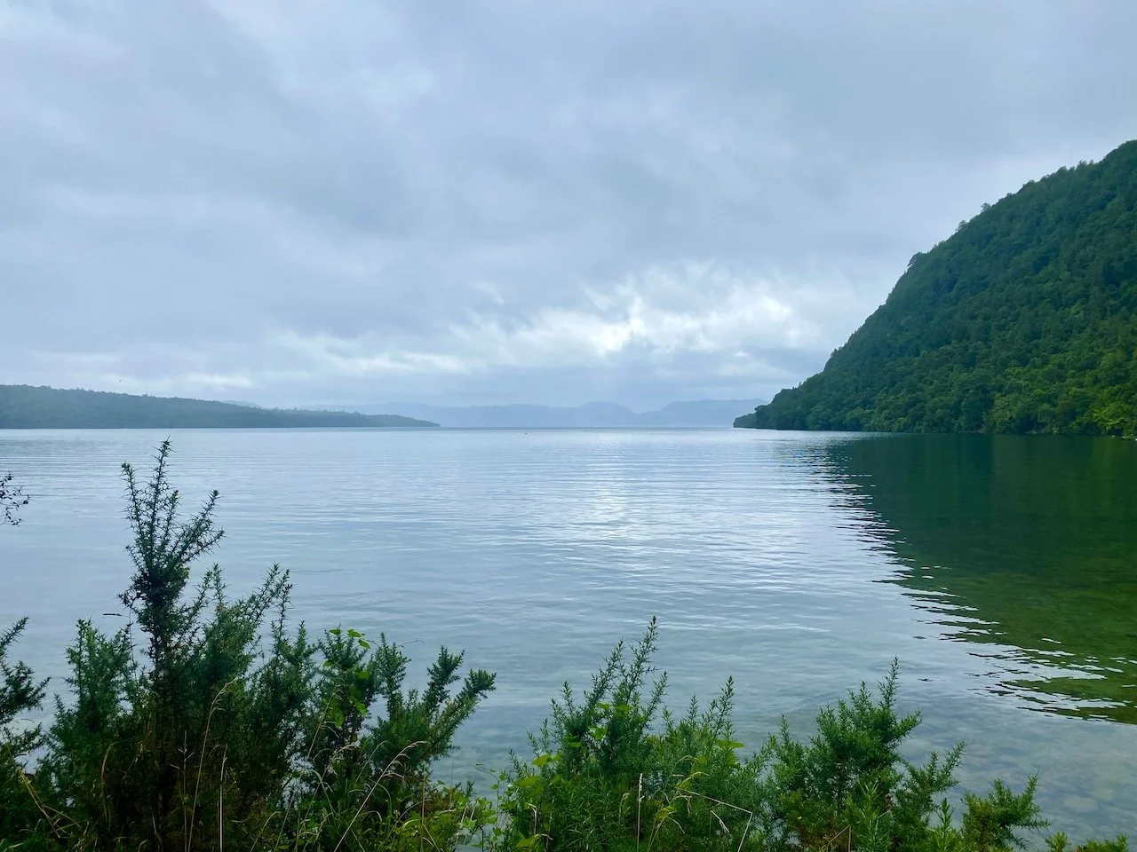 Calm waters of Lake Tarawera reflecting the clouds