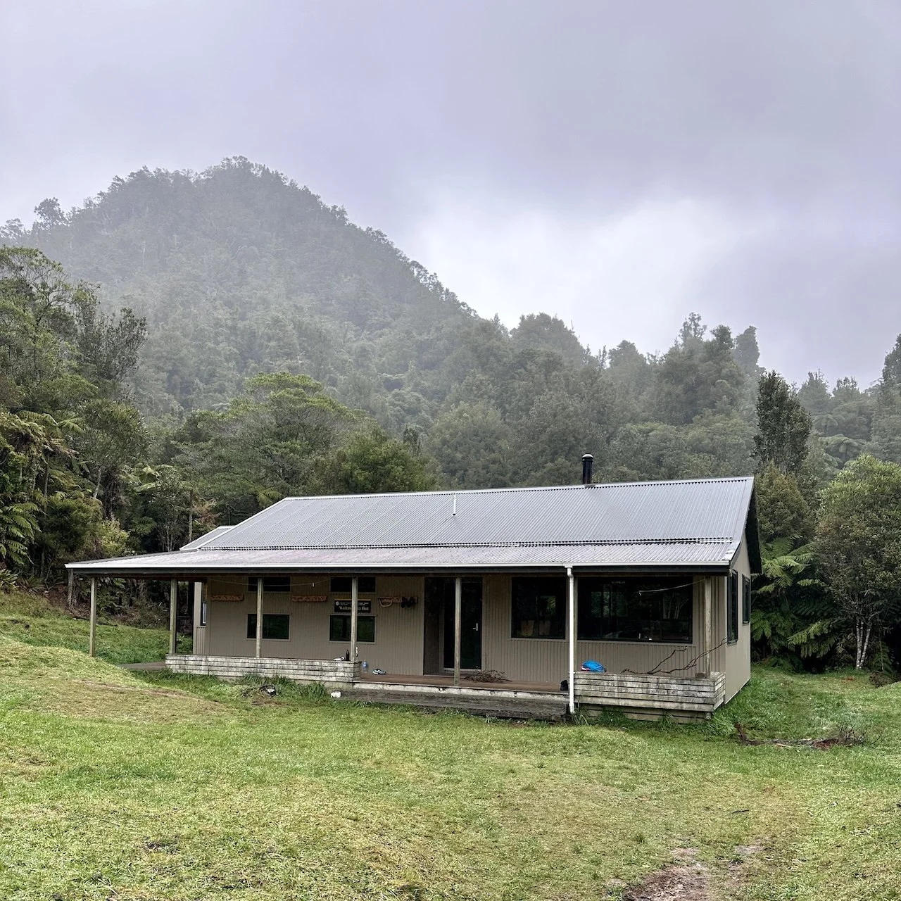 The Waitawheta Hut pictured with misty forest behind