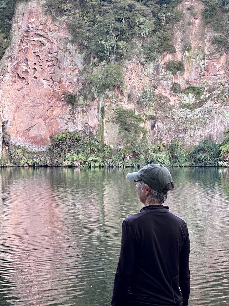 Hiker looking across the Waikato River to towering cliffs near Arapuni
