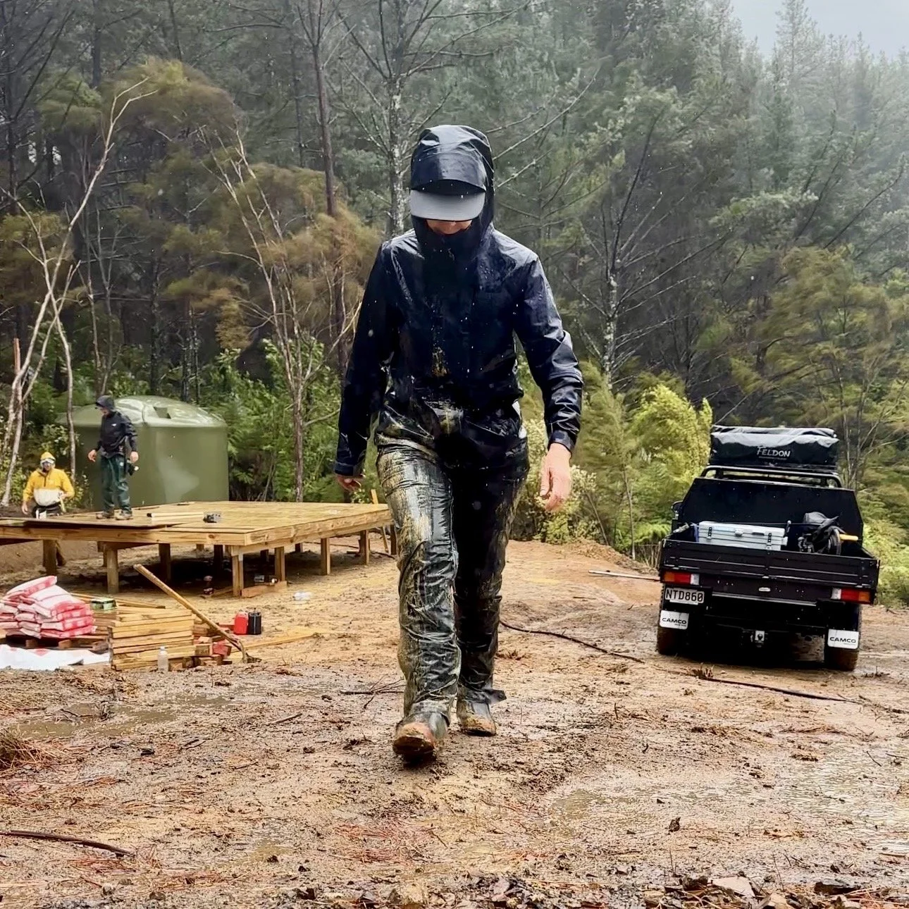 Woman wearing muddy wet weather clothes at rainy building site