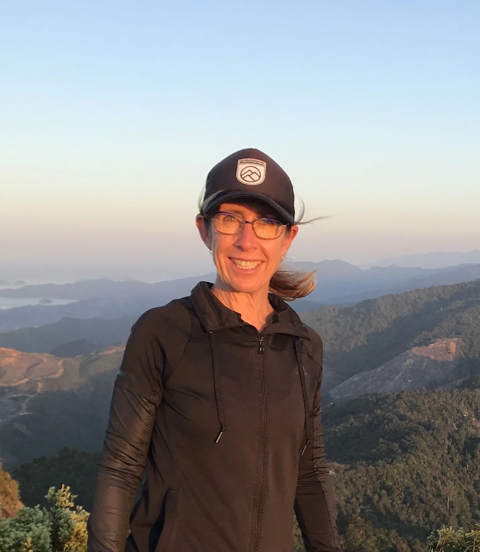 Hiker on mountain top with panoramic view behind