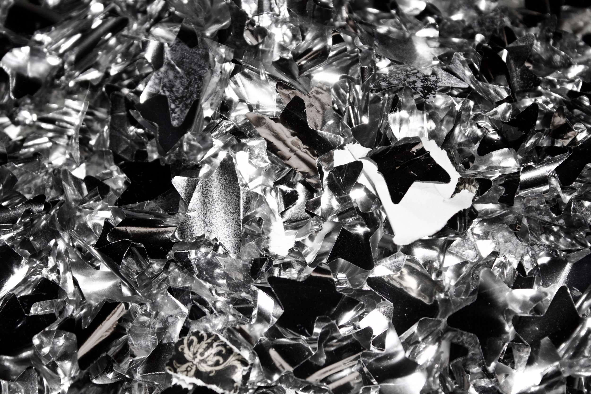Close-up of shiny, fragmented metallic material, possibly aluminum or foil, with reflective surfaces and sharp edges.