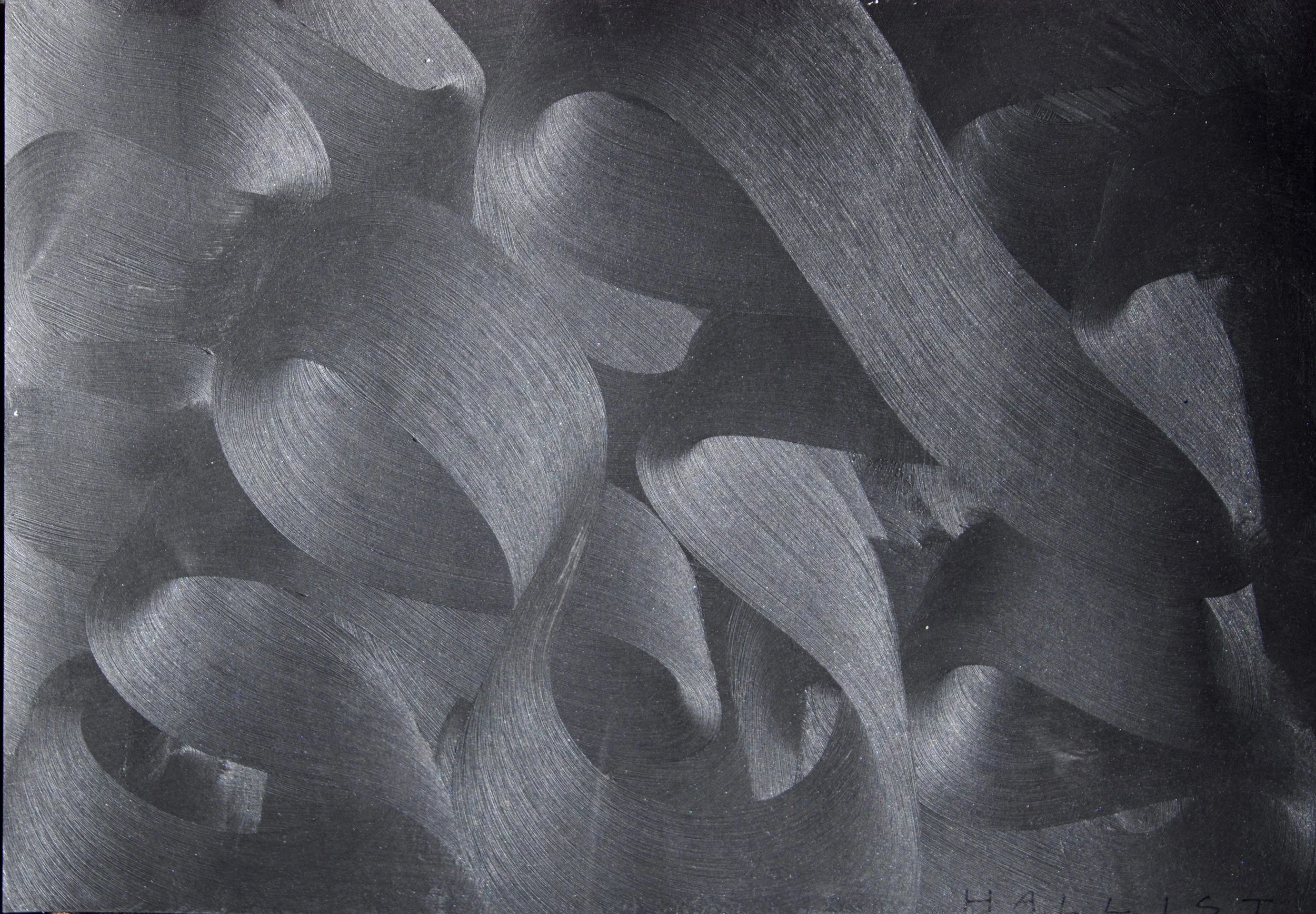 Close-up of a black surface with silver, curved, swirling brushstrokes.