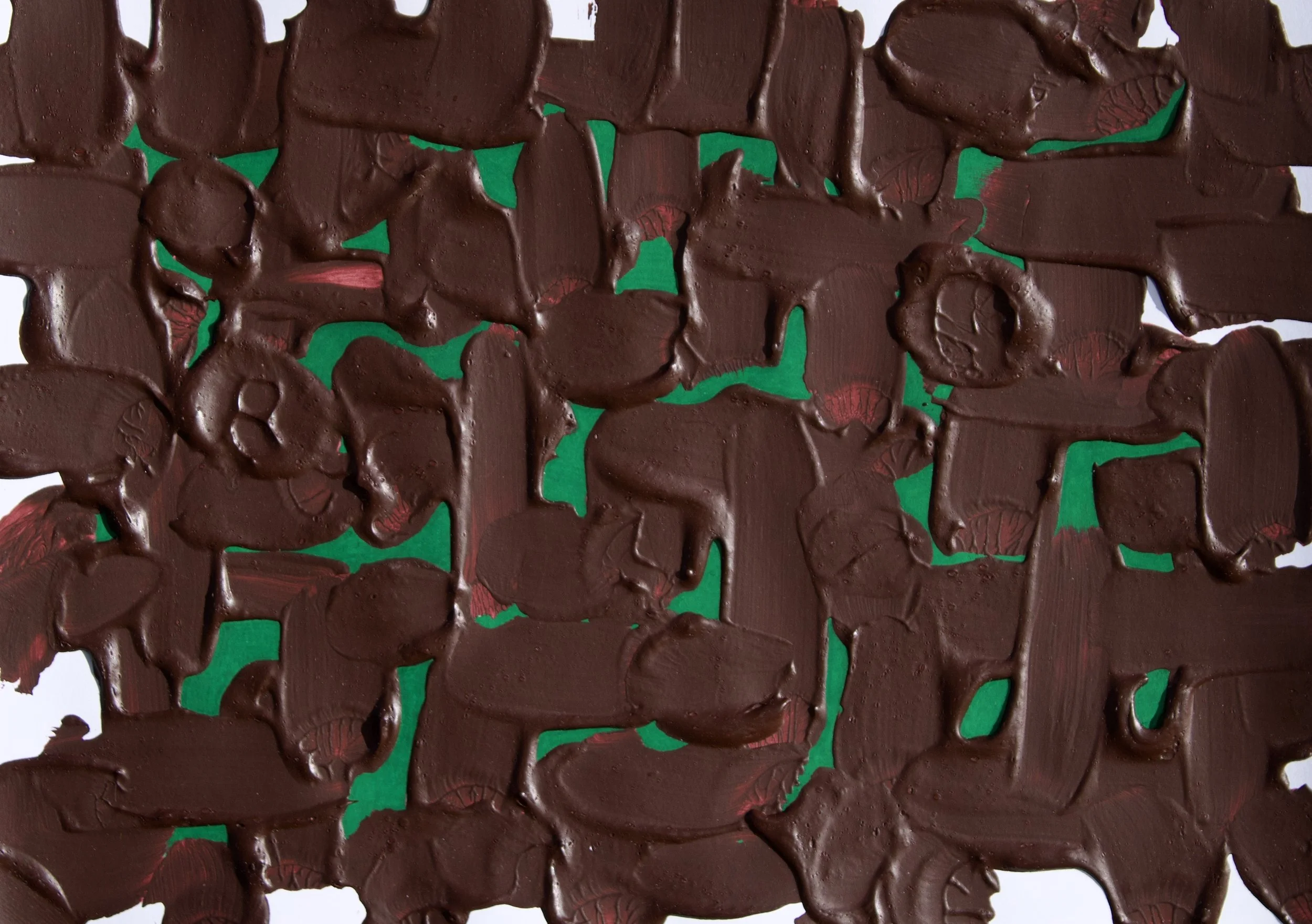 Close-up of a piece of broken chocolate with green and red backing paper underneath.