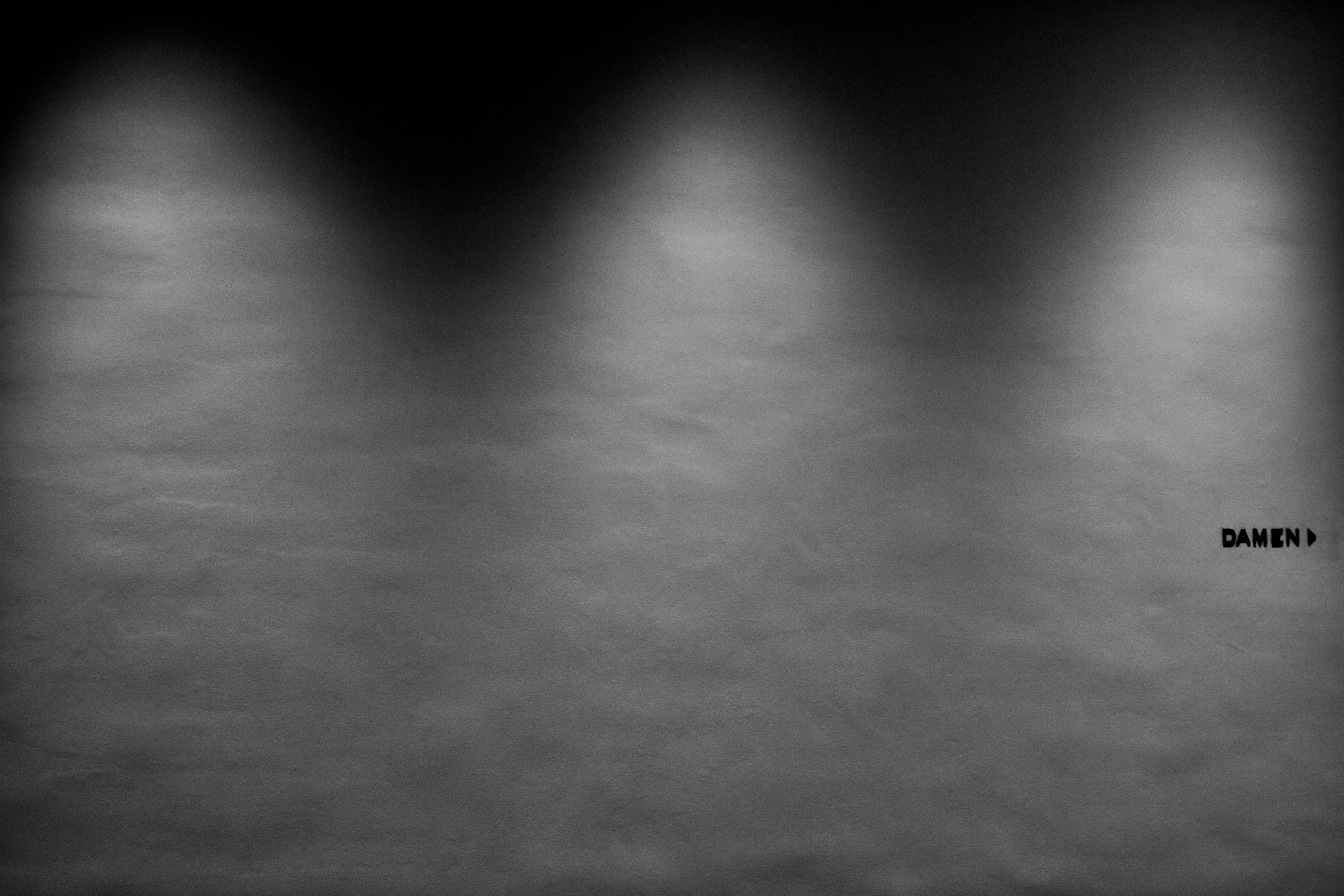 Black and white image of a foggy or cloudy sky with the word 'DAMEN' in bold uppercase letters at the bottom right corner.