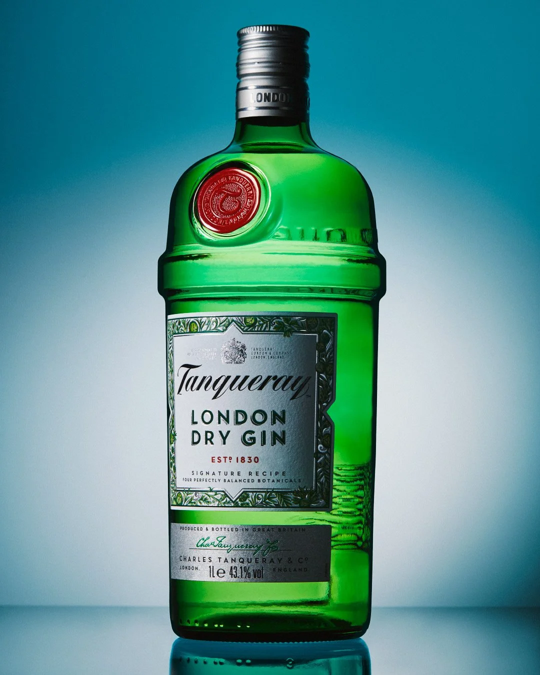 Tanqueray London Dry Gin bottle in iconic green glass with red wax seal against a teal background.