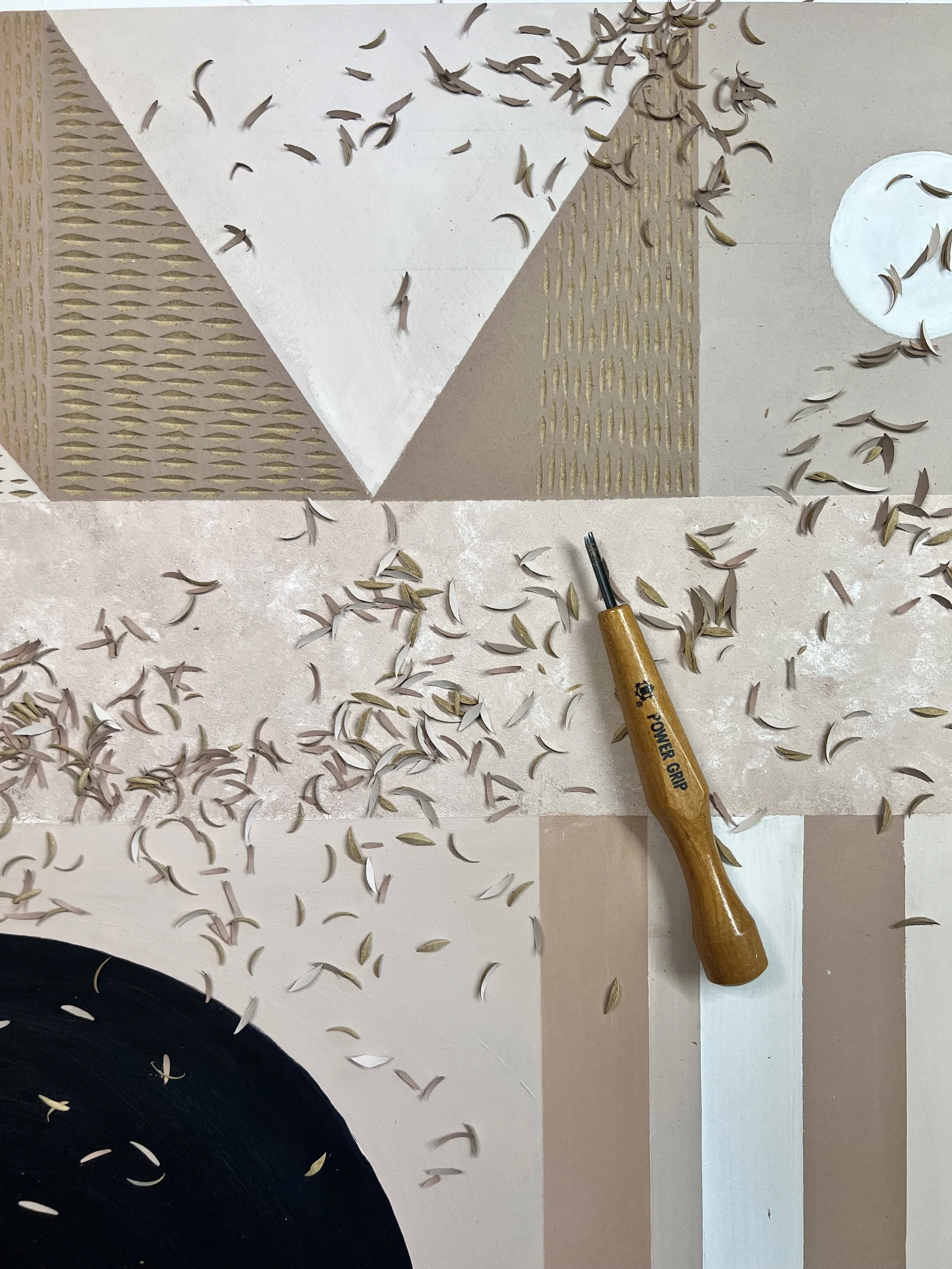 Wood carving tool with wood shavings on abstract geometric art canvas with beige, white, and black shapes.