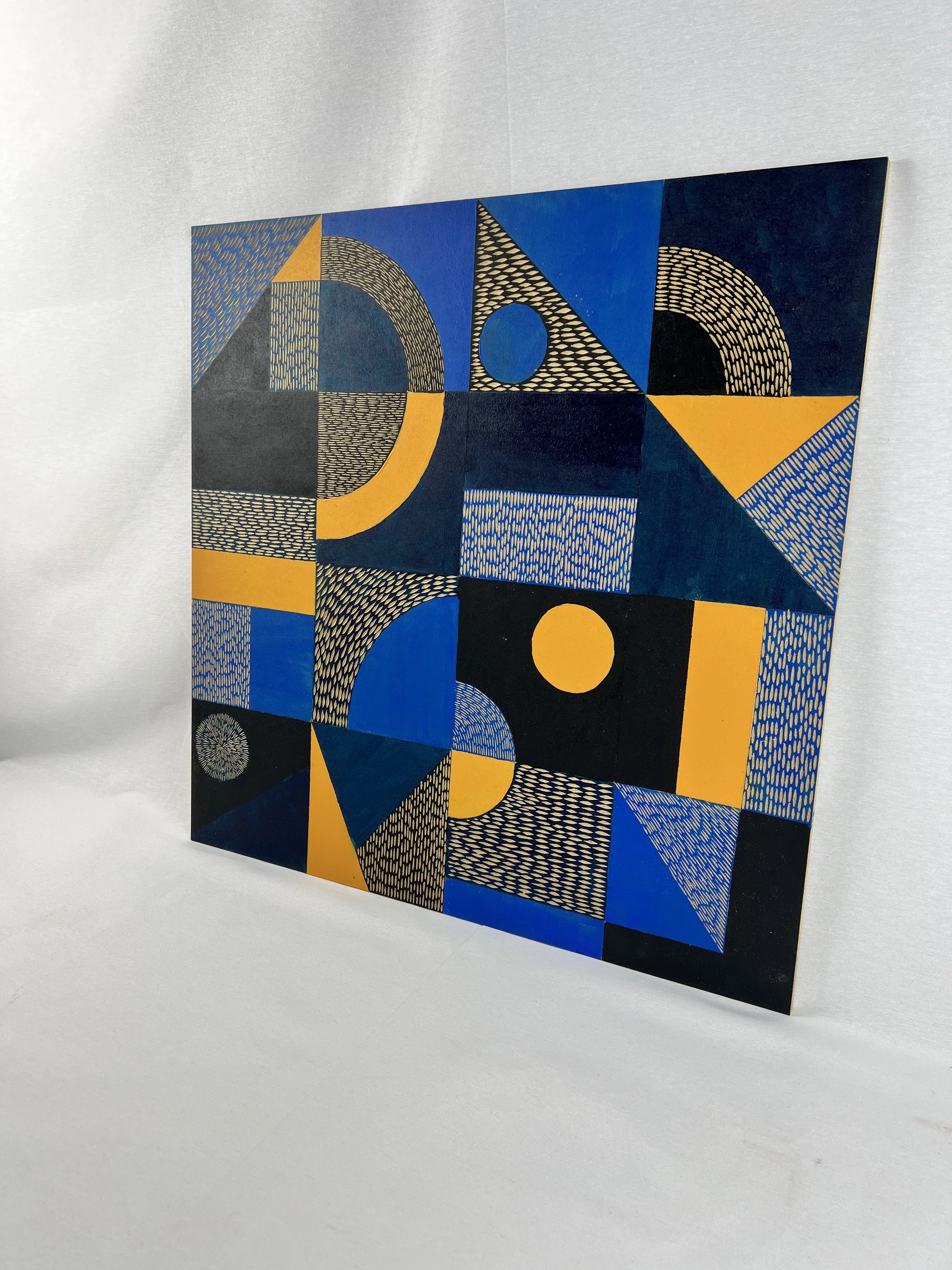 Abstract geometric artwork with blue, black, and yellow shapes on a white background.