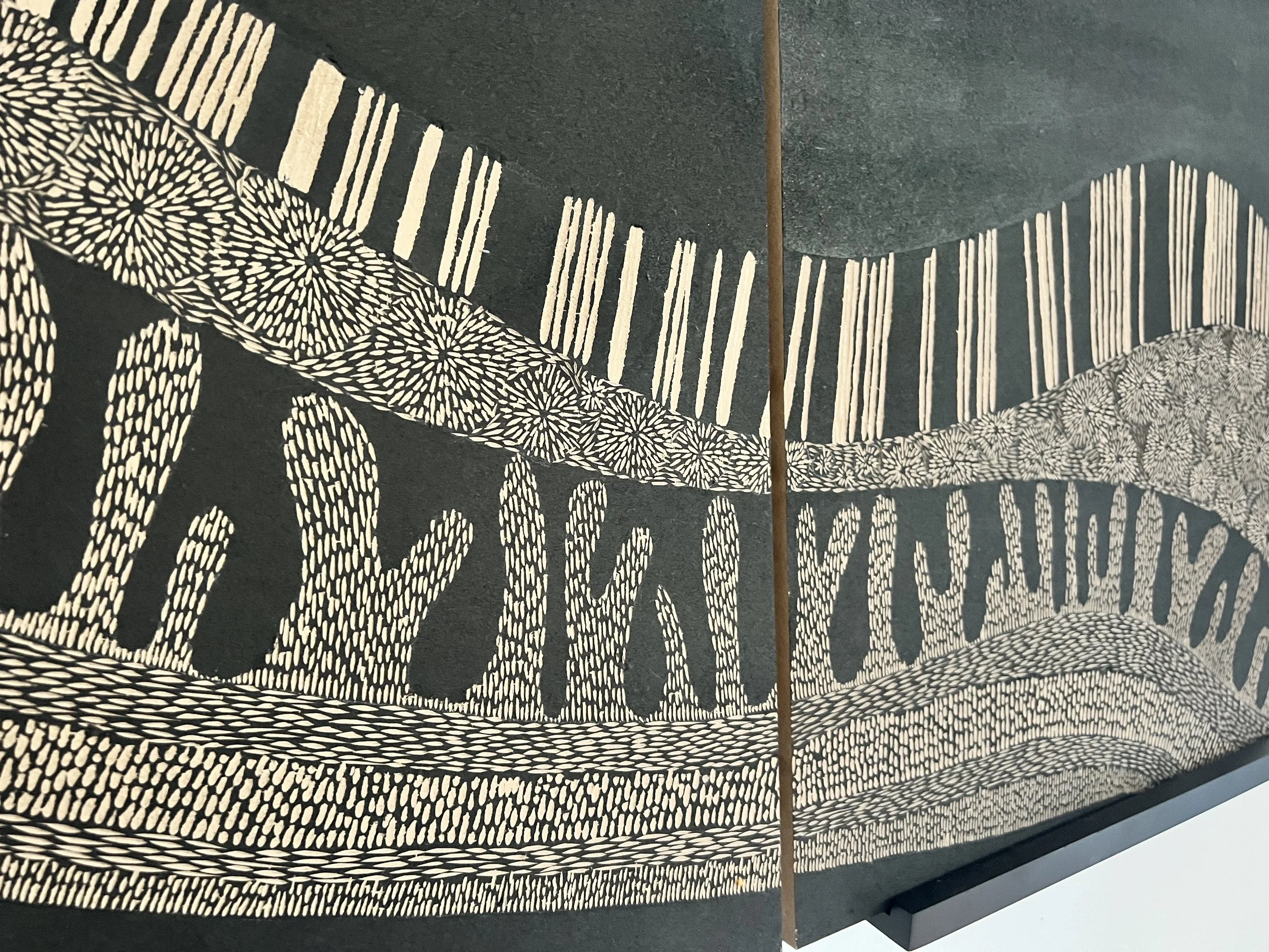 Abstract black and white artwork featuring intricate patterns and lines creating a wave-like design.