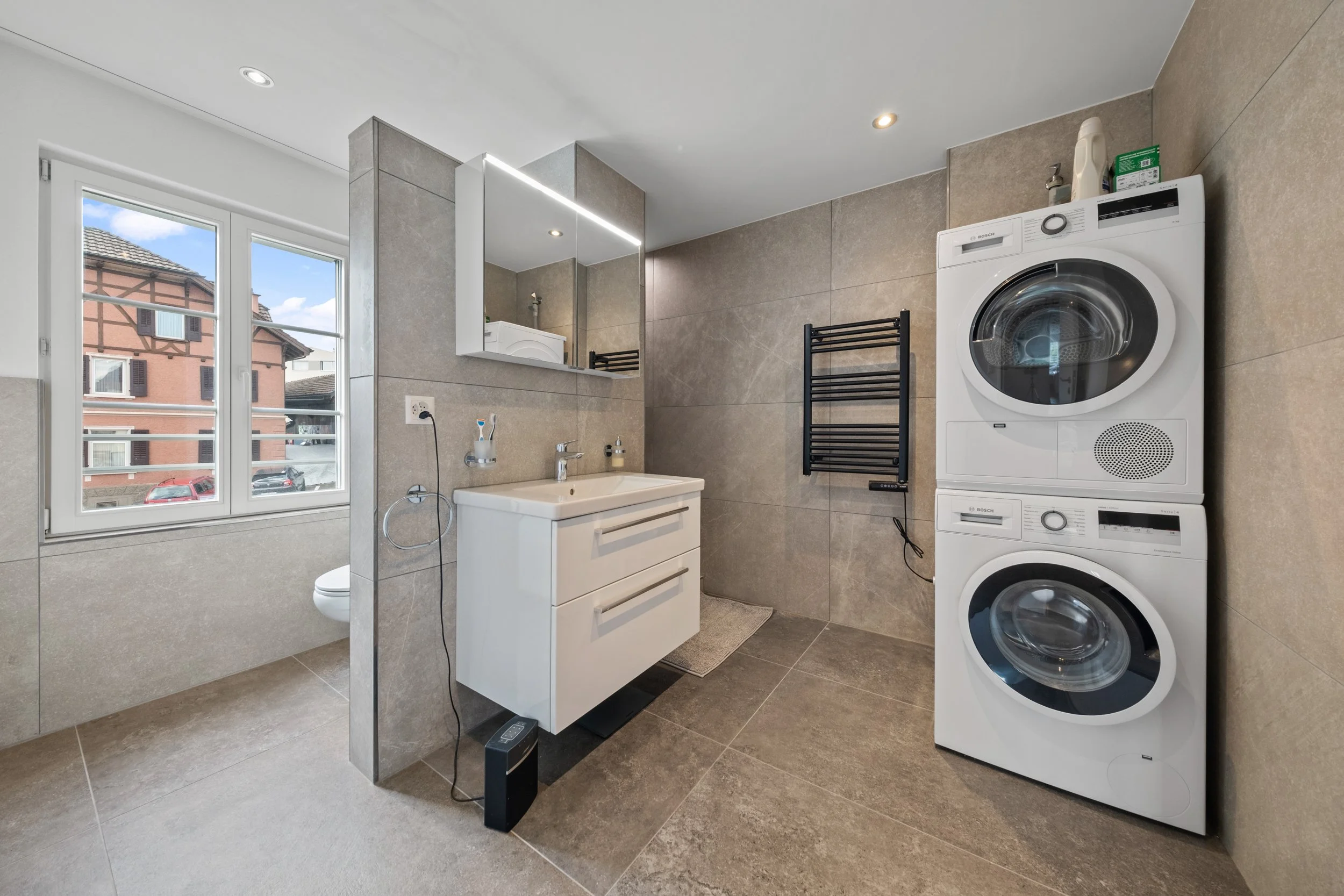 Badezimmer mit Waschturm und Handtuchradiator