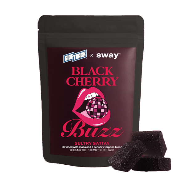 Package of Black Cherry Buzz Sativa cannabis edibles next to two gummy candies on a pink background.