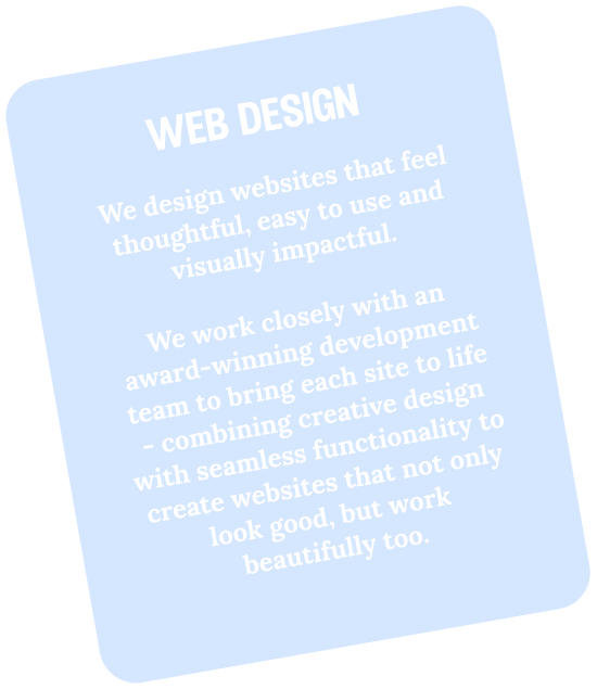 A light blue rectangular sign tilted on a black background, with white text promoting web design services.