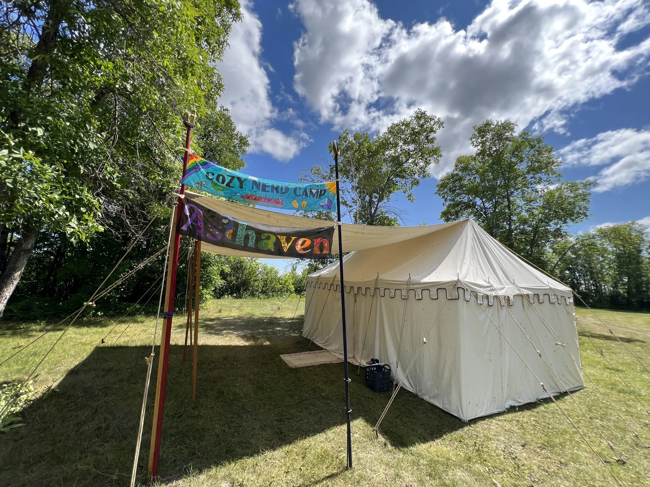 A canvas tent with two banners against a sunny background